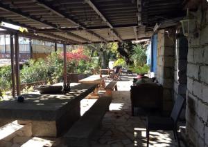 a patio with tables and chairs under a roof at Chambre Belvédère in Porto-Vecchio