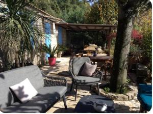 a patio with two chairs and a bench and a table at Chambre Belvédère in Porto-Vecchio