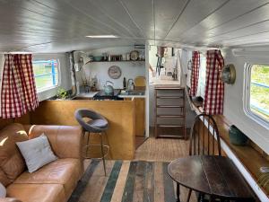 a living room with a couch and a kitchen in a trailer at Barge in central Cambridge in Cambridge