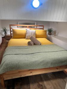 a bedroom with a large yellow bed with a teddy bear on it at Barge in central Cambridge in Cambridge