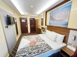a hotel room with a bed and a tv at Naif Palace Hotel in Dubai