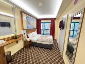 a small room with a bed and a mirror at Naif Palace Hotel in Dubai