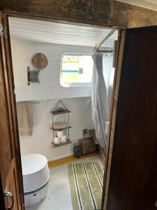 a small bathroom with a toilet and a window at Barge in central Cambridge in Cambridge +17 photos
