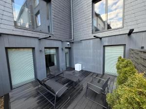 a patio with chairs and a table and some windows at Botanical Garden Loft in Kaunas