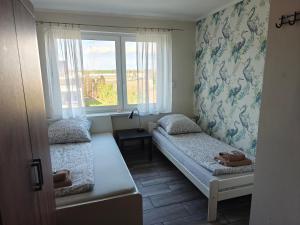 a small room with two beds and a window at Villa 106 in Pawłów