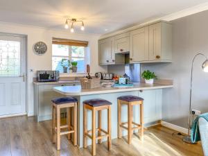 a kitchen with a counter and stools in it at 2 Bed in York oc-81052 in Helmsley