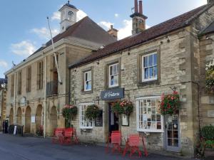 an old stone building with red chairs in front of it at 2 Bed in York oc-81052 in Helmsley
