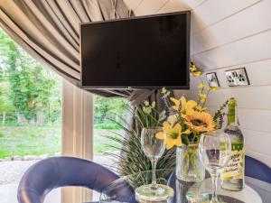 a table with a tv and flowers and wine glasses at 1 Bed in Consett oc-87933 in Shotley Bridge +8 photos