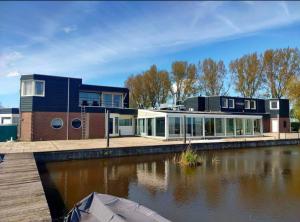 a house on a dock next to a body of water at Weromerie Premium Hotel and Apartment in Wormer