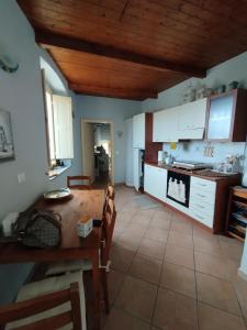 a kitchen with white cabinets and a wooden ceiling at Casa Adamo 77 in Badolato