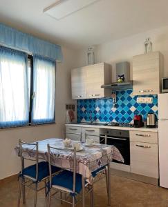 a kitchen with a table and chairs in a kitchen at Domu Bella in Decimomannu