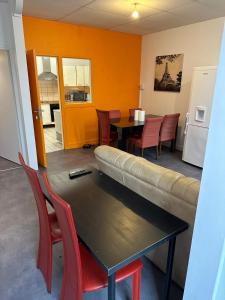 a living room with a couch and a table and chairs at Hôtel de la gare - Chambre standard in Tarbes
