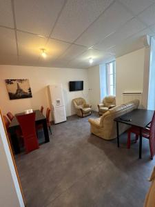 a large living room with a table and chairs at Hôtel de la gare - Chambre standard in Tarbes
