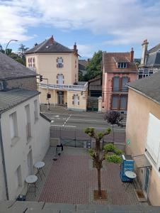 a courtyard with tables and chairs in a city at Hôtel de la gare - Chambre standard in Tarbes