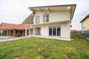 a large house with a lawn in front of it at Super Vila in Jajinci