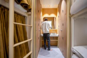 a man standing in a bathroom looking in a mirror at The Central House Valencia Mercado Central in Valencia