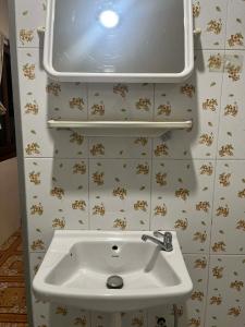 a bathroom with a sink and a tv on the wall at Yao noi cozy home in Ko Yao Noi