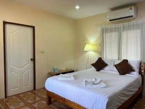 a bedroom with a large white bed with towels on it at Yao noi cozy home in Ko Yao Noi