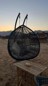 a basket chair sitting on top of a table at Heaven Dune Camp in Nuweiba