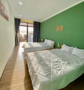 two beds in a room with green walls at Xóm Chài Homestay in Thôn Sơn Hải +15 photos