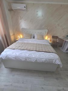 a bedroom with a white bed with lights on it at Apartament Severin Caple in Drobeta-Turnu Severin