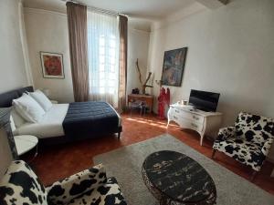 a living room with a bed and a couch and a tv at Ô Anges in Arles