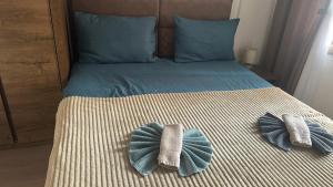 a bed with two pillows on top of it at Pine & Peak Zlatibor Apartman in Zlatibor