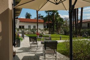 a patio with a table and chairs and an umbrella at Gio Leo Guest House in Lesa