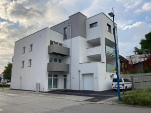 a white building with a car parked in front of it at Ferienwohnung Bad Schallerbach in Bad Schallerbach
