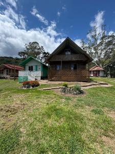 a house in a field with a yard at Cabanas Romeu & Julieta in Cambará