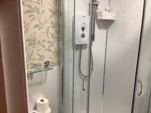 a shower in a bathroom with a glass door at Edenbank Hotel in Dumfries +63 photos