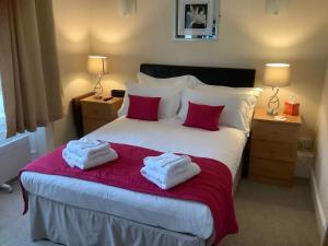 a bedroom with a bed with two towels on it at Edenbank Hotel in Dumfries