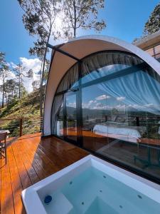 a tub on a deck with a bed in a tent at The Domes Jarabacoa in Jarabacoa