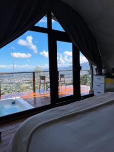 a bedroom with a tub and a view of the ocean at The Domes Jarabacoa in Jarabacoa +38 photos