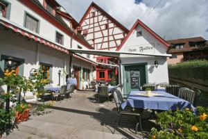 patio ze stołami i krzesłami przed budynkiem w obiekcie Landhaus Zum Falken w mieście Tauberzell