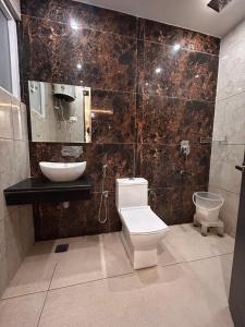 a bathroom with a toilet and a sink at Garden view by Midtown in Katra