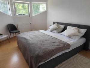 a large bed in a bedroom with two windows at u koupaliste in Mimoň