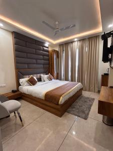 a bedroom with a large bed and a television at Garden view by Midtown in Katra