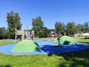 a playground with two green tents in a park at u koupaliste in Mimoň