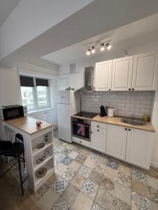 a kitchen with white cabinets and a sink and a counter at Central Studio Yoko , Craiova in Craiova