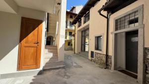 an alley with a wooden door in a building at Glicine in Stresa