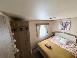 a bedroom with a bed in a small room at Caravan Turnberry 2 , Seton Sands, Wifi in Port Seton