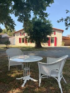 a table and two chairs sitting in the grass at La marmotte in Le Vanneau
