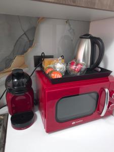 a red microwave with a tea pot on top of it at Apartament Severin Caple in Drobeta-Turnu Severin