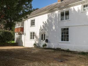 a white house with a driveway in front of it at Rectory Cottage in Alton