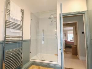 a shower in a bathroom with a glass door at Rectory Cottage in Alton