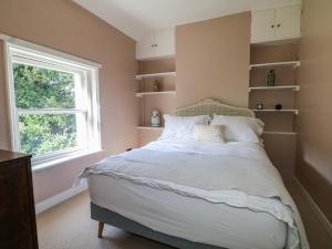 a bedroom with a large bed and a window at Rectory Cottage in Alton