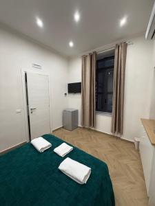 a bedroom with a green bed with two towels on it at HV Carbonara 123 in Naples