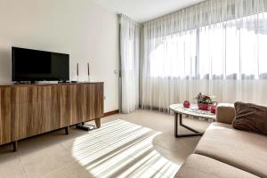 a living room with a couch and a tv at Doble Playa in Playa Paraiso