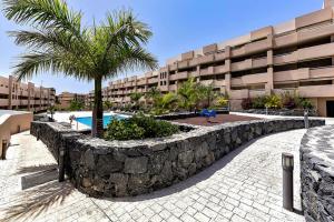 a resort with a stone wall and a swimming pool at Doble Playa in Playa Paraiso